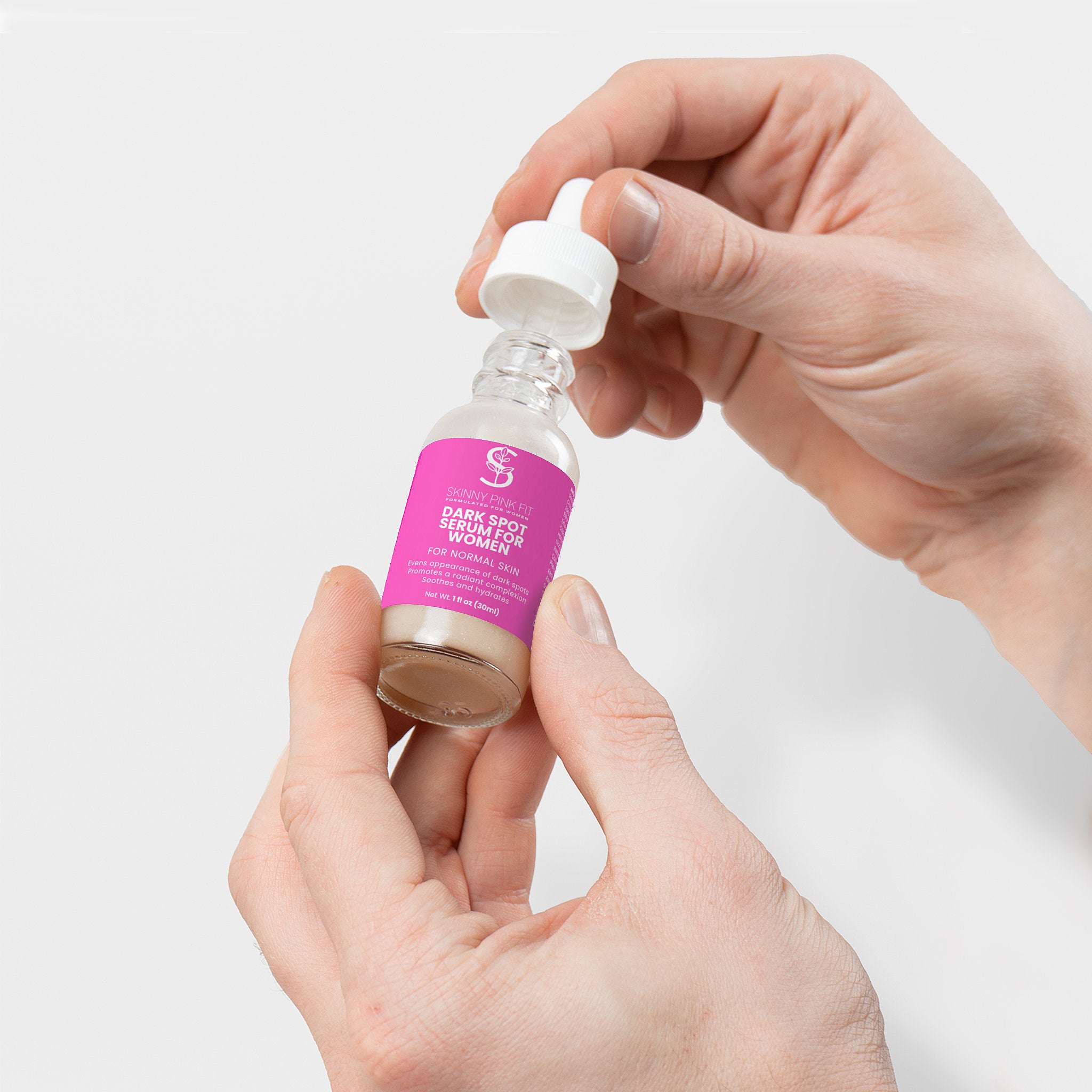 Hand holding a small bottle with a pink label against a light gray background Dark Spot Serum for Normal Skin For Women, Skinny Pink Fit