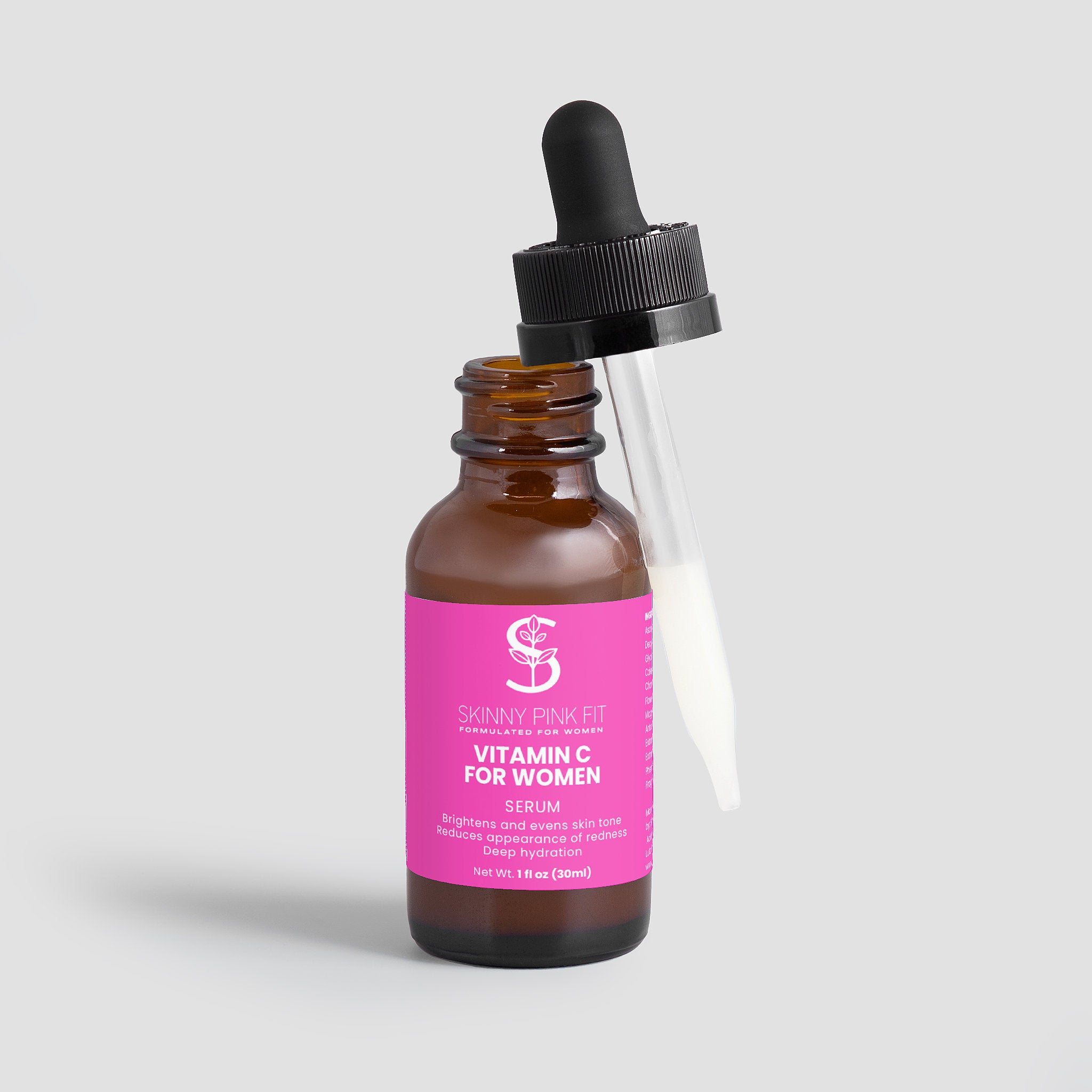 Vitamin C serum bottle with pink label on a light gray background Skinny Pink Fit